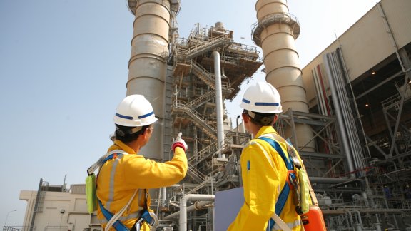 Two workers in safety gear onsite at a plant