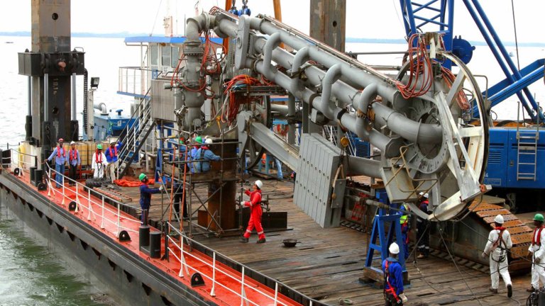 Un bras de chargement est démonté et transféré sur une barge.