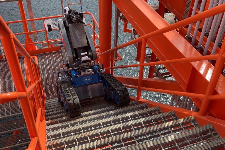 Un véhicule robotique naviguant sur les escaliers d'une plateforme offshore, illustrant la technologie avancée dans les environnements marins