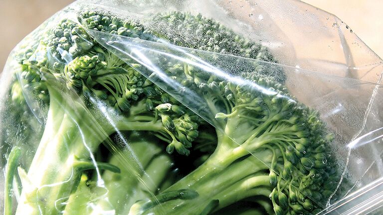 Fresh broccoli florets wrapped in clear plastic film