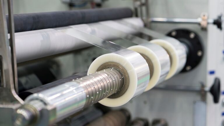 A roll of tape is being rolled on a machine