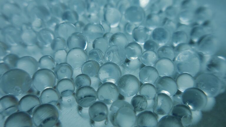 Close-up of silica-based supports and catalysts with translucent beads reflecting light