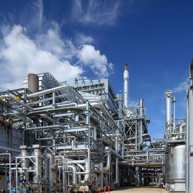 Industrial plant with metal pipes and structures under a blue sky