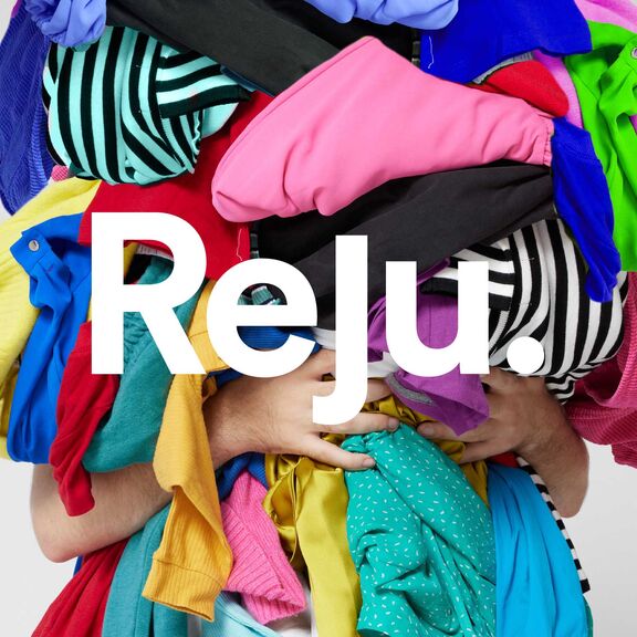 Picture of someone holding a pile of colorful clothes with the Reju logo written on top