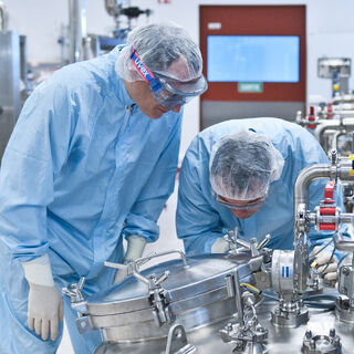 Banner image showing two persons working at a pharmaceutical plant built by Technip Energies