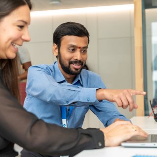 A man and a woman looking at a laptop