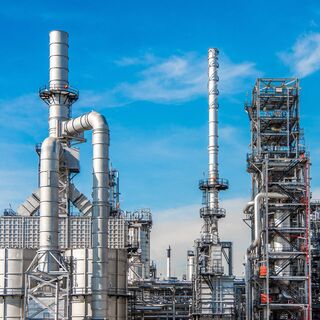 Industrial facility with large pipes and towers against a blue sky