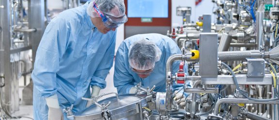 Banner image showing two persons working at a pharmaceutical plant built by Technip Energies