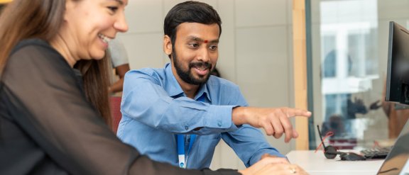 A man and a woman looking at a laptop