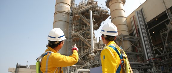 Two workers in safety gear onsite at a plant