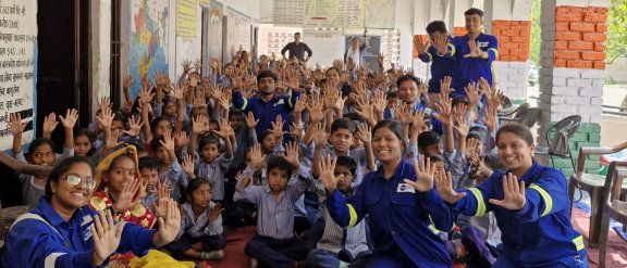Un groupe de personnes souriantes levant les mains pour célébrer le programme RSE Seed of Hope en Inde