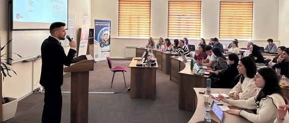 A speaker presents the Baku Master technology transfer program to an engaged audience of students.
