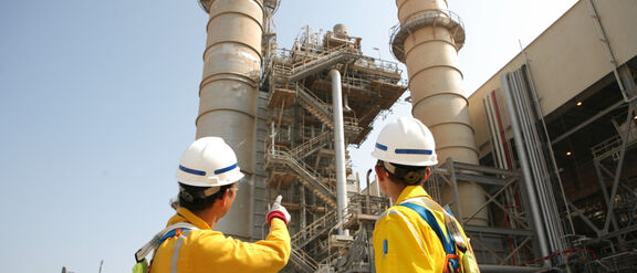 Two workers in safety gear onsite at a plant