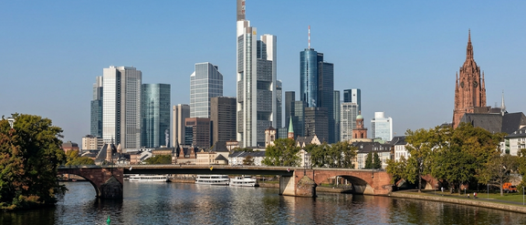 Frankfurt skyline with modern skyscrapers and a bridge over the Main River.