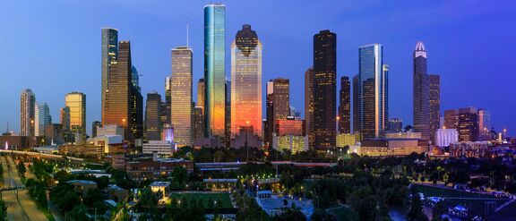 Houston downtown skyline at dusk with illuminated skyscrapers.