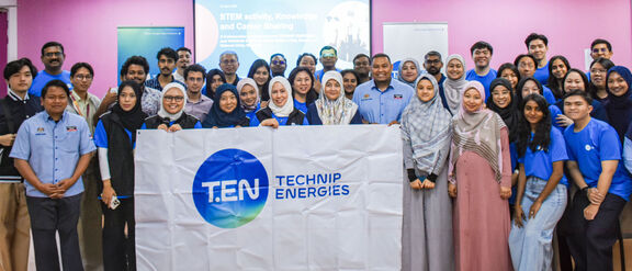 Group picture of students participating in SHINE program, holding a banner with Technip Energies' logo