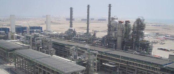 Industrial facility with large structures, set against a desert landscape