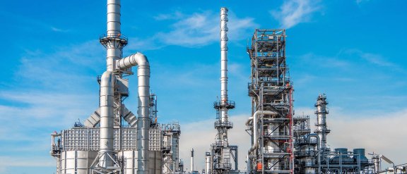 Industrial facility with large pipes and towers against a blue sky