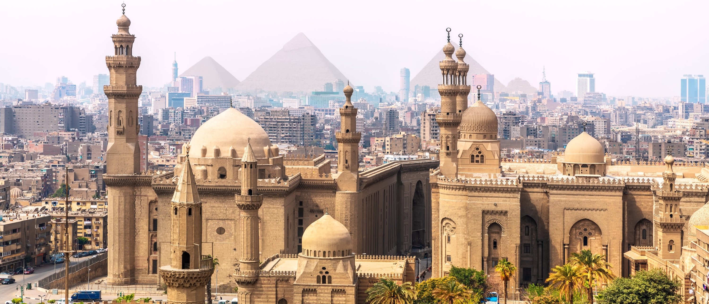 Image of buildings in Cairo with pyramids in the background