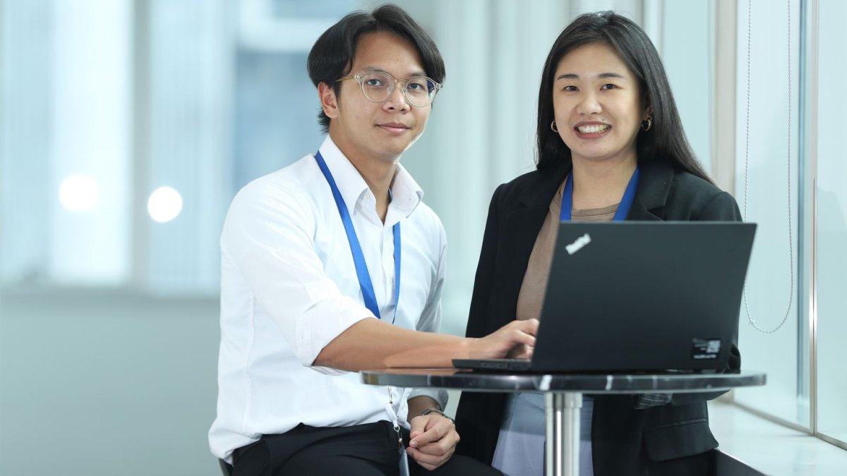 A man and a woman in front of a laptop