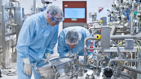 Banner image showing two persons working at a pharmaceutical plant built by Technip Energies