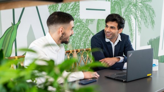 Two male Technip Energies employees talking and smiling