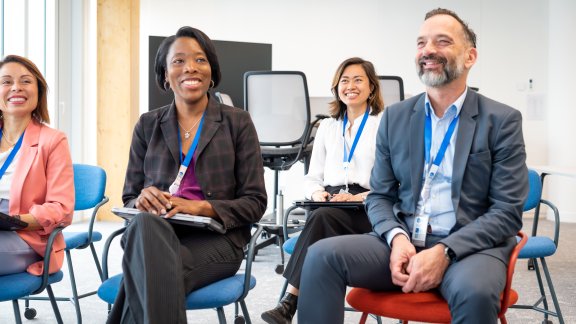 Diverse group of women and men sitting together and smiling