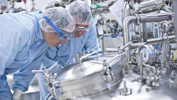 Banner image showing two persons working at a pharmaceutical plant built by Technip Energies