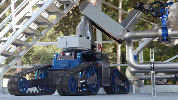 Robotic machine with tracks and an articulated arm