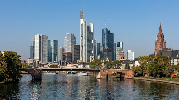 Frankfurt skyline with modern skyscrapers and a bridge over the Main River.
