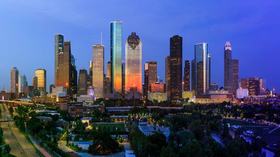 Houston downtown skyline at dusk with illuminated skyscrapers.