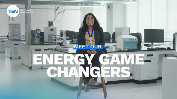 A woman seated on a stool in a modern laboratory setting with the text ‘Meet Our Energy Game Changers’ displayed.