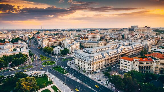 Aerial view of Romania at sunset, showing historic buildings, wide boulevards and busy intersections