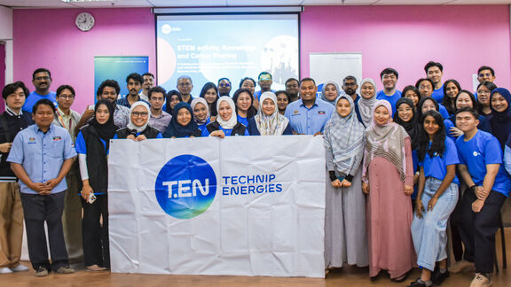 Group picture of students participating in SHINE program, holding a banner with Technip Energies' logo