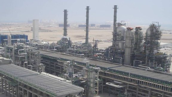 Industrial facility with large structures, set against a desert landscape