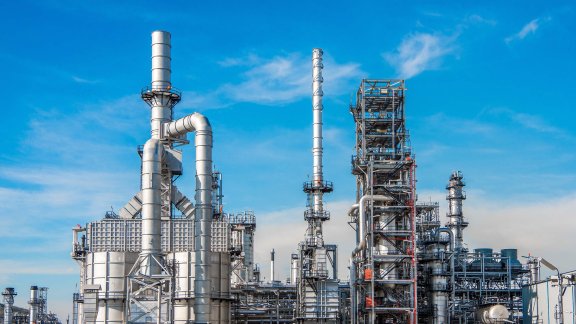 Industrial facility with large pipes and towers against a blue sky